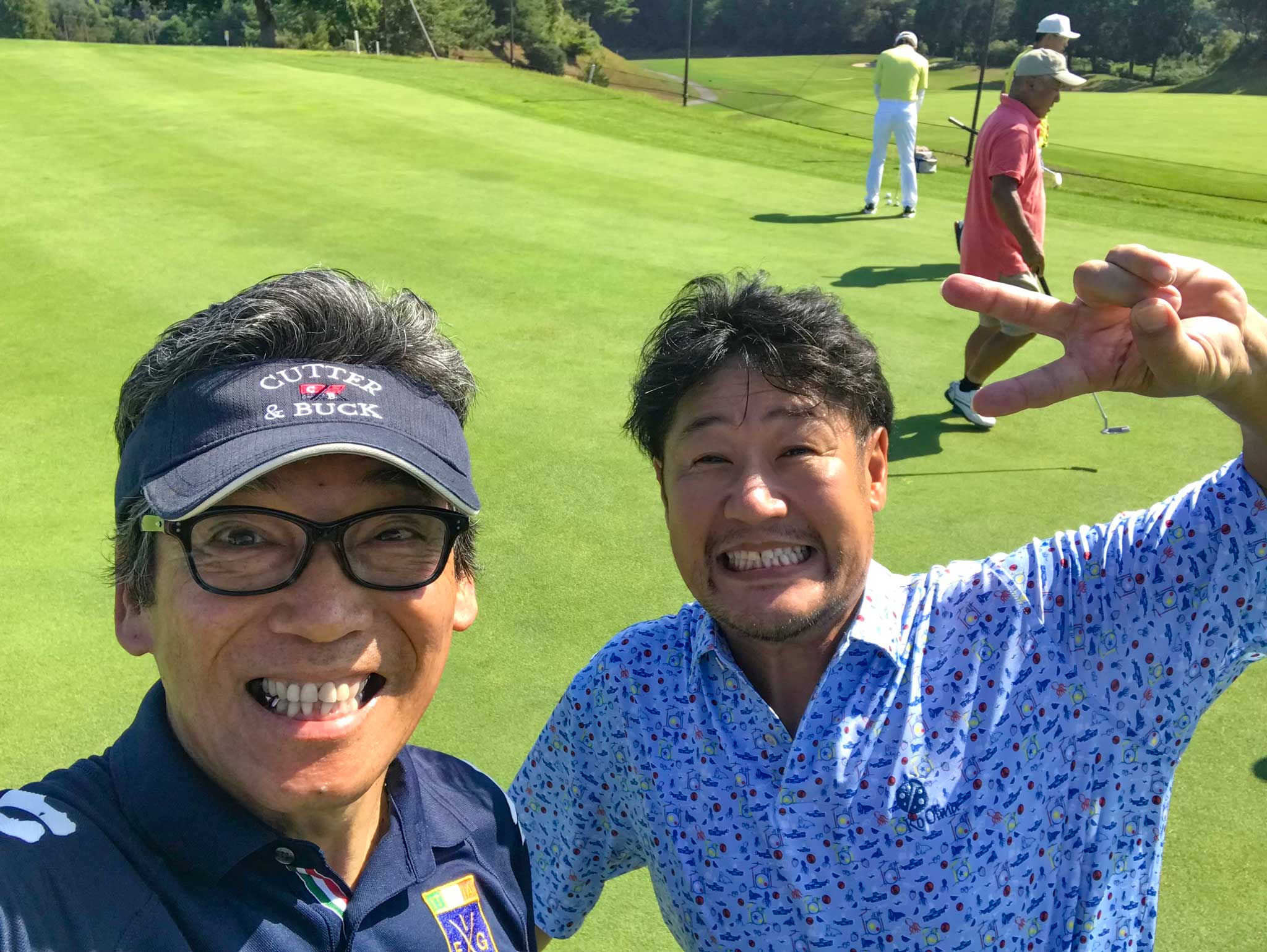 パッティング練習する関西ゴルフサークル セブンエイトの湯浅光一と黒木さんの写真