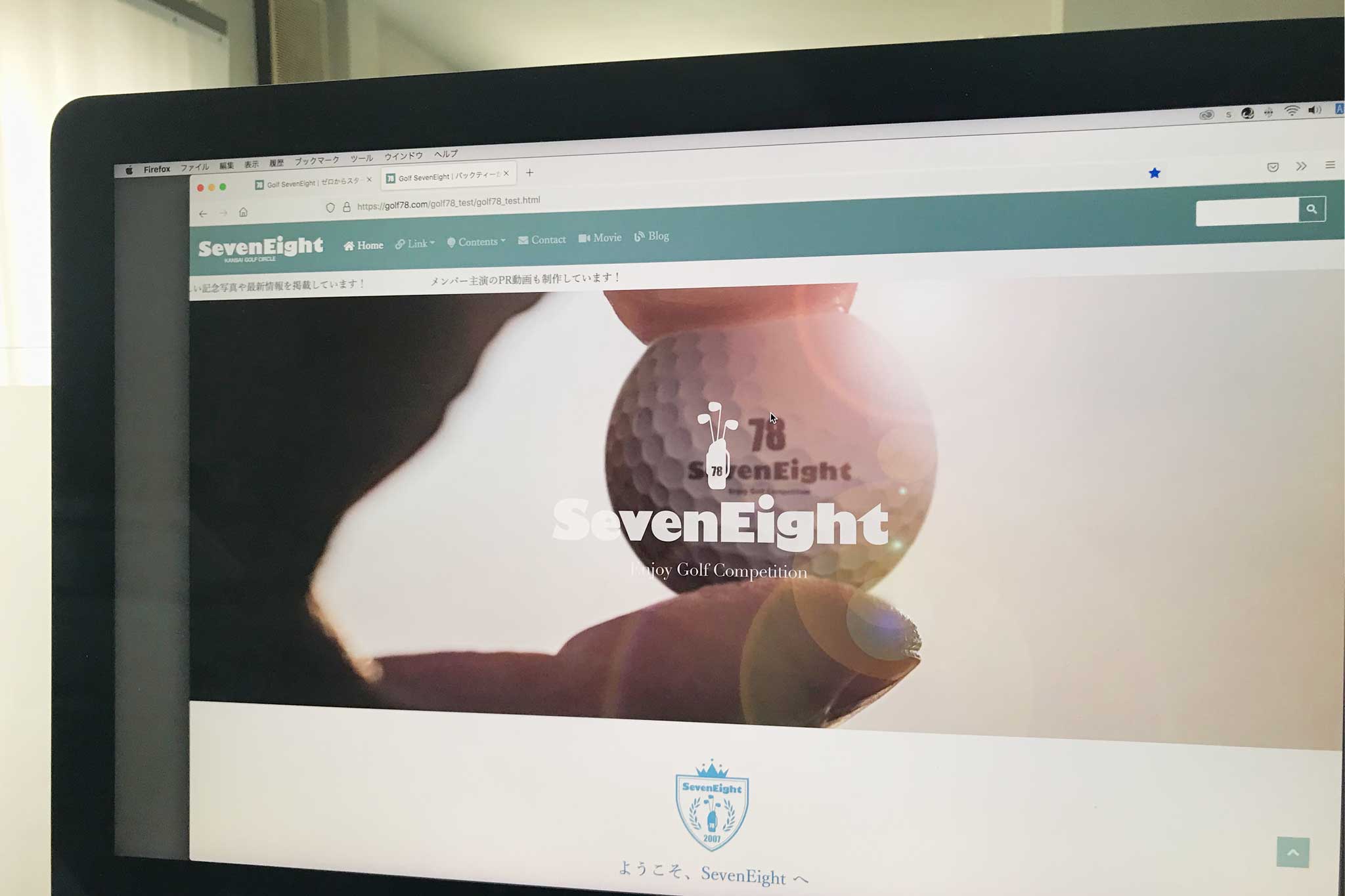 モニターに映るゴルフサークルセブンエイトのホームページデザイン