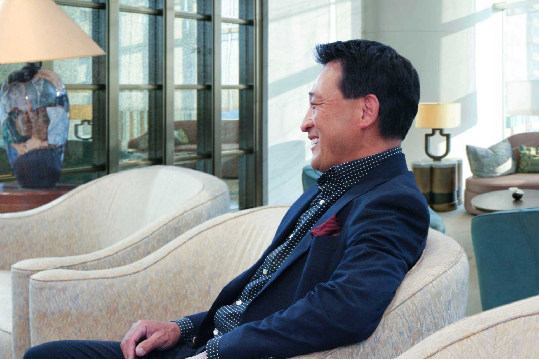 ソファーに腰掛ける関西ゴルフサークル セブンエイトのメンバー中村光宏さん