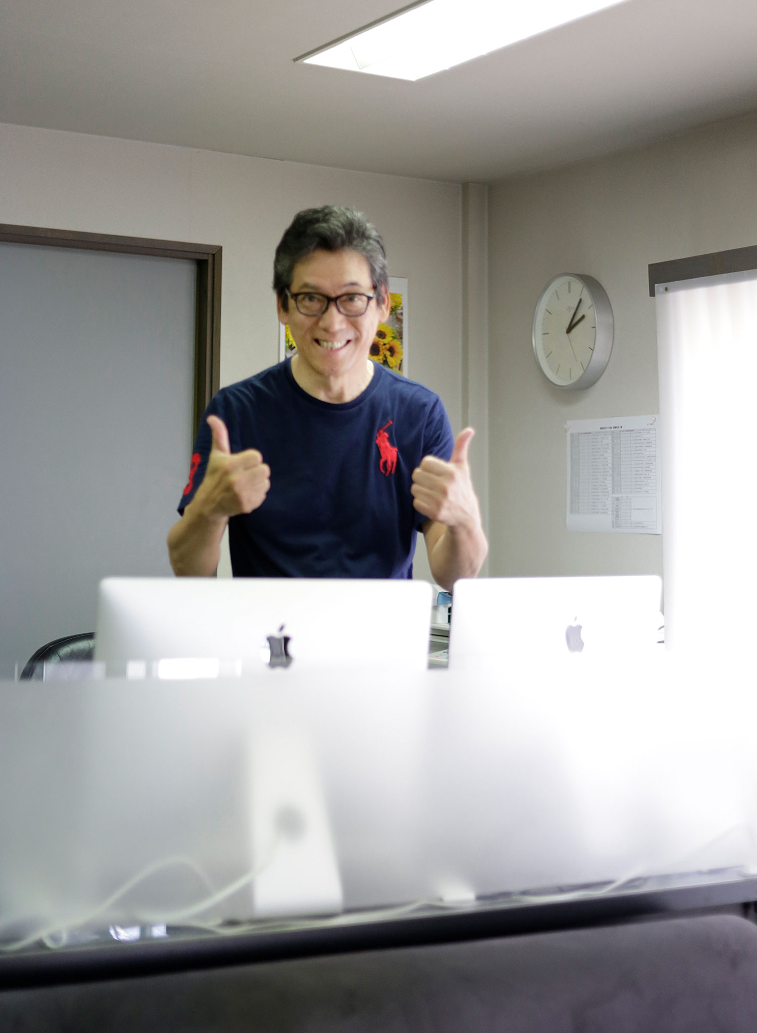 パソコンの前でポーズする関西ゴルフサークル セブンエイトの湯浅光一