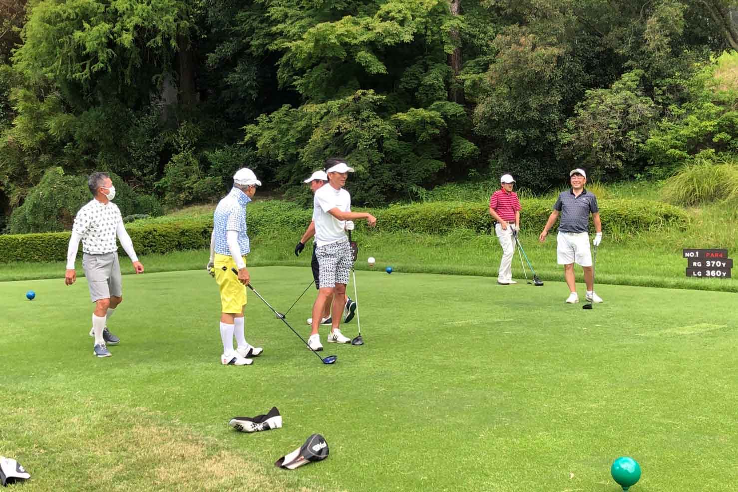 ティーグランドで談笑するゴルフサークルセブンエイトのメンバー