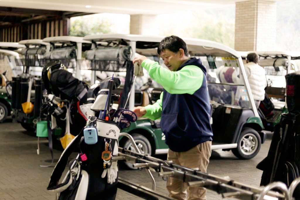 クラブを持って練習に向かう関西ゴルフサークル セブンエイトの大橋正明さん