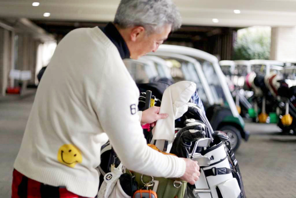 クラブを持って練習に向かう関西ゴルフサークル セブンエイトの松村元喜さん