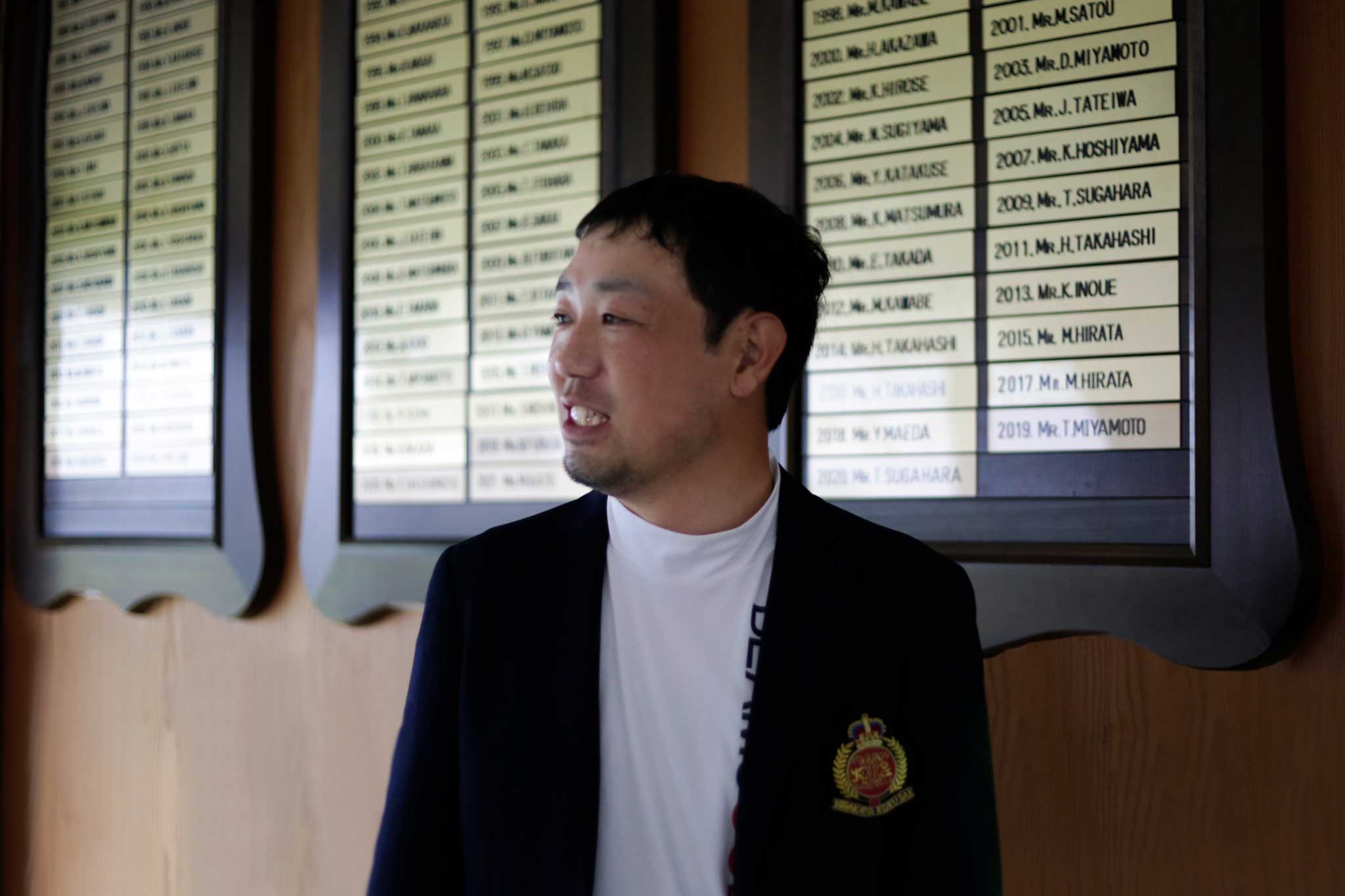 チャンピオンボードの前でインタビューに答える平田さん