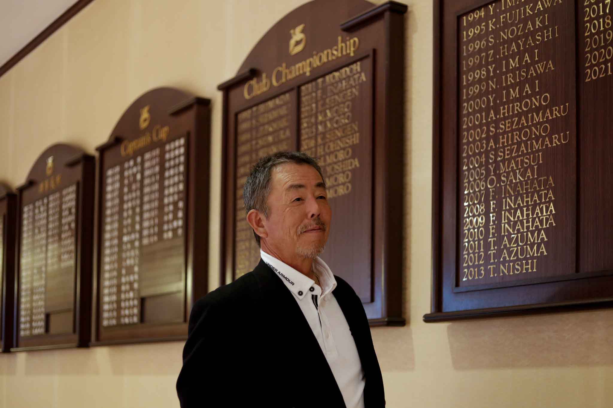 チャンピオンボードを見ながらインタビューに答える大西均さん